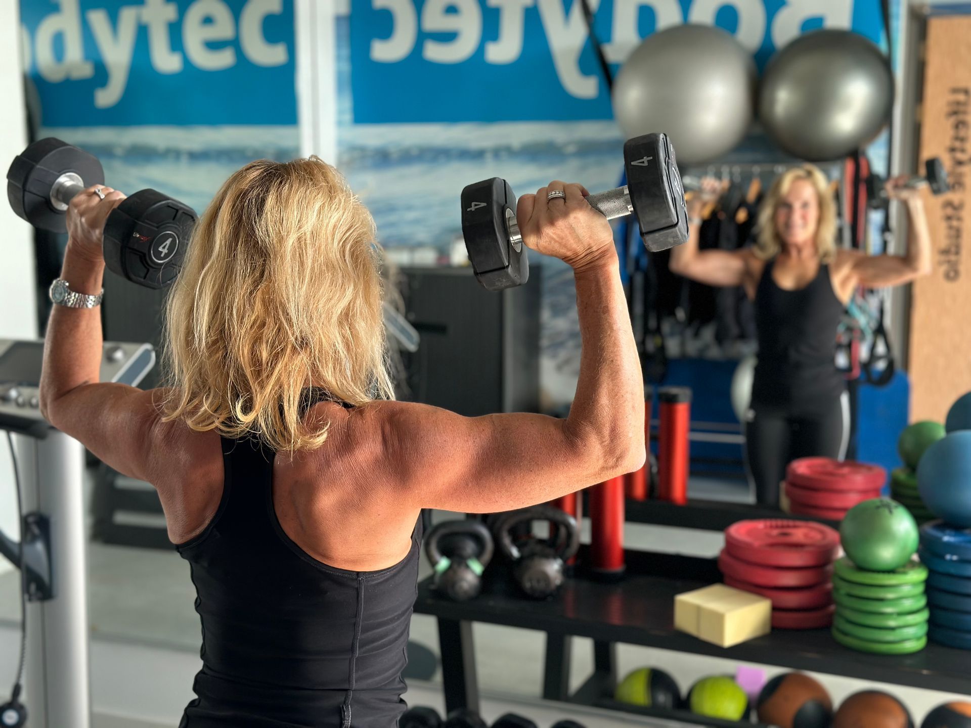 Een vrouw tilt een halter op in een sportschool.