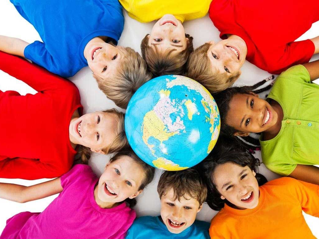 Kids laying on the ground around a globe