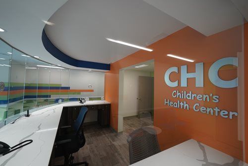 Children's Health Center reception area with glass walls and orange accent wall