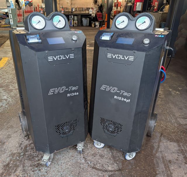 Two black Evolve industrial machines with gauges in a workshop setting