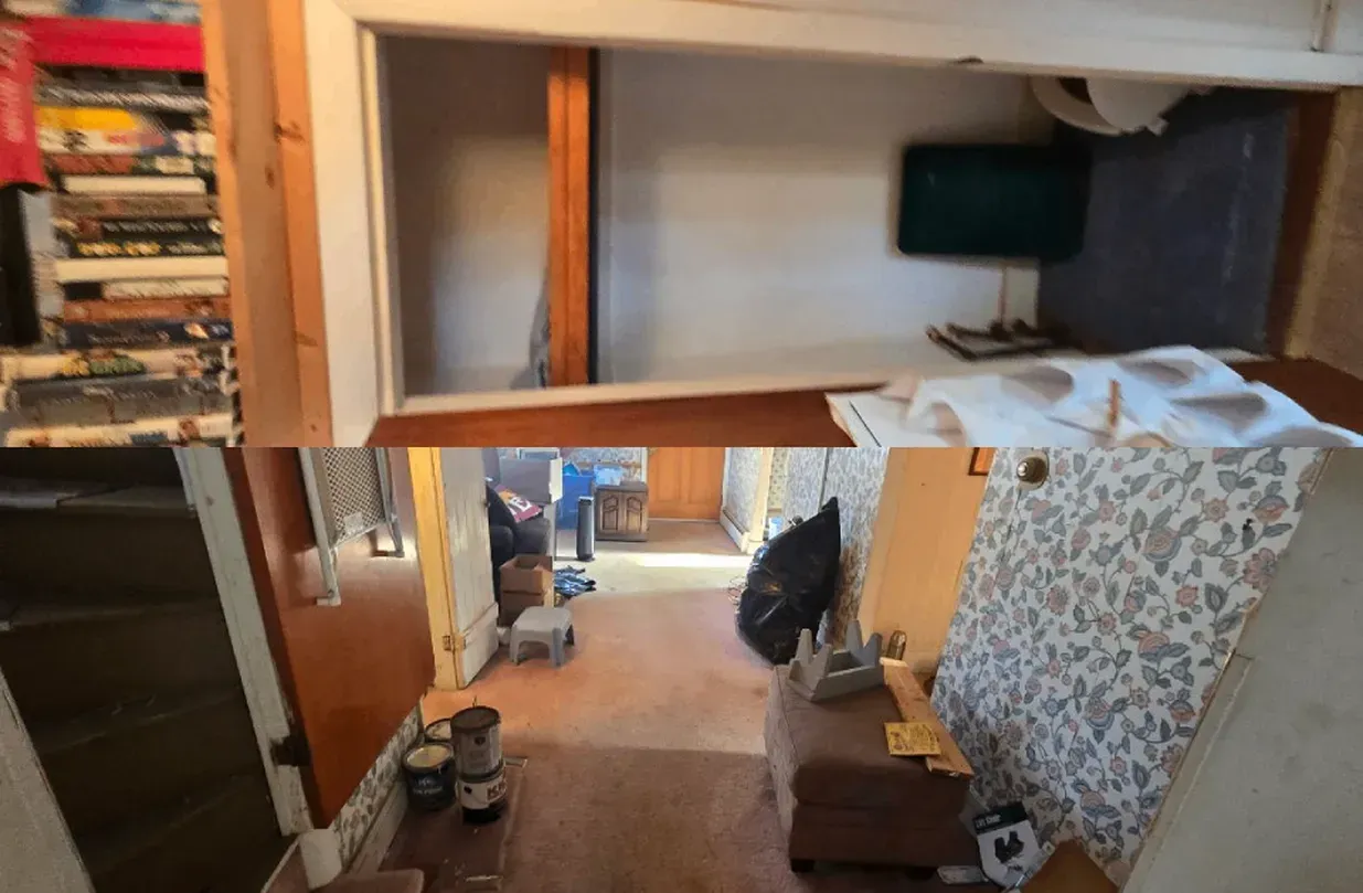 Cluttered hallway and bedroom with open doors, shelves of books, boxes, and a bed with patterned cover.