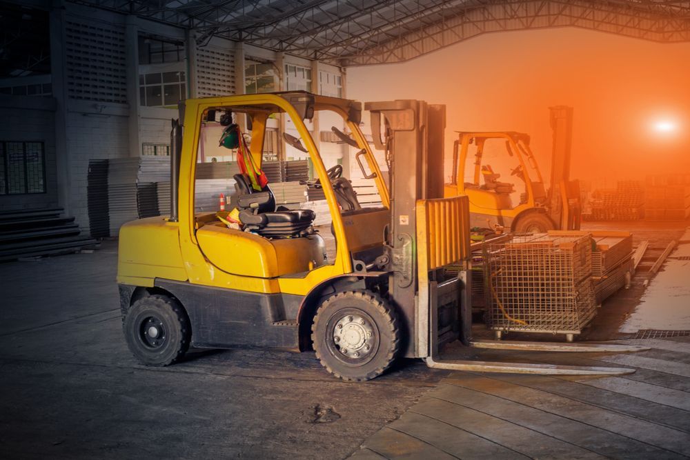 Yellow Forklift Carrying Stacked Wire Baskets in a Warehouse at Dusk — Barkly Hire in Dugald River, QLD
