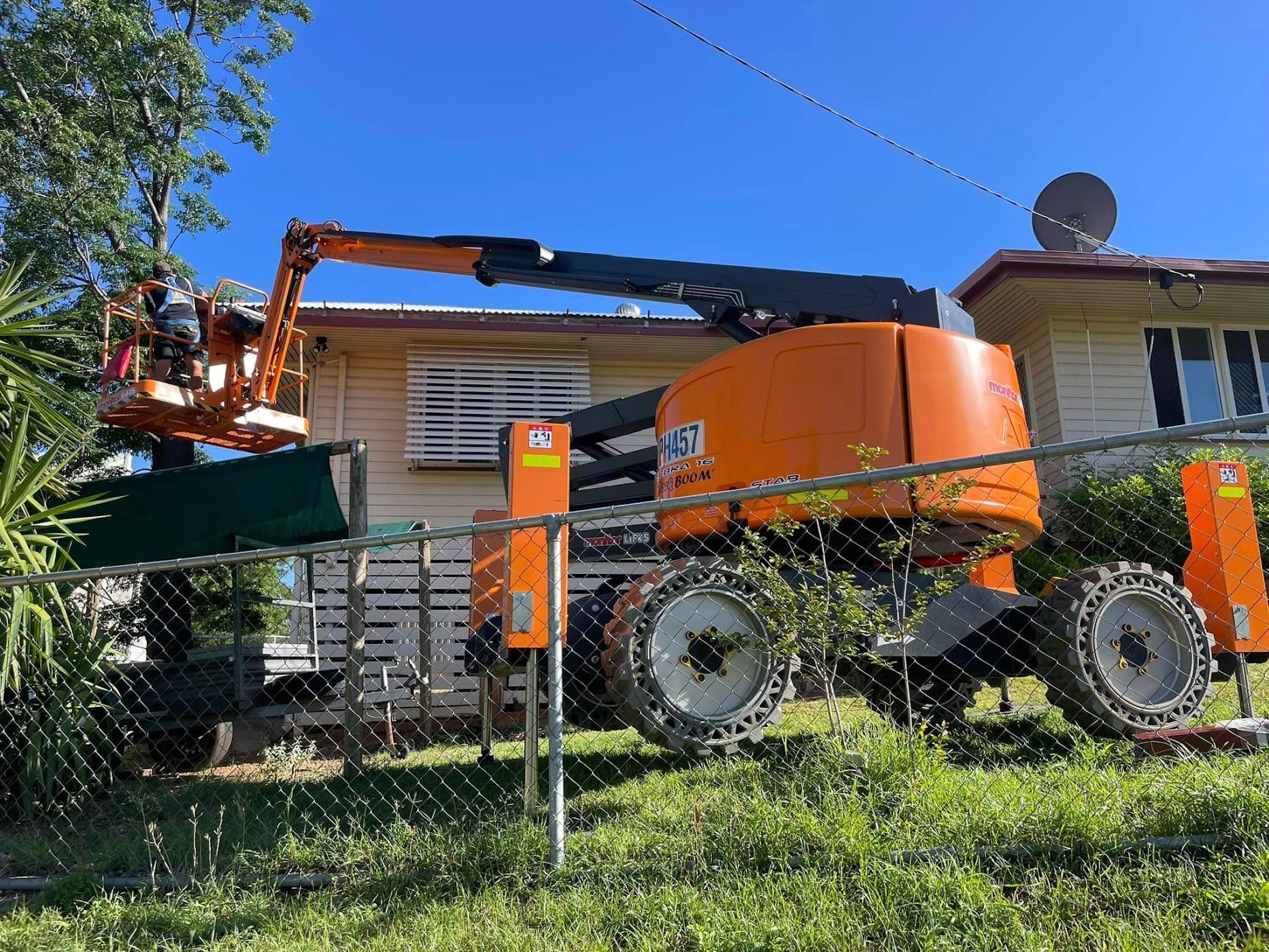 Orange Cherry Picker Parked Beside a House — Barkly Hire in Ryan, QLD