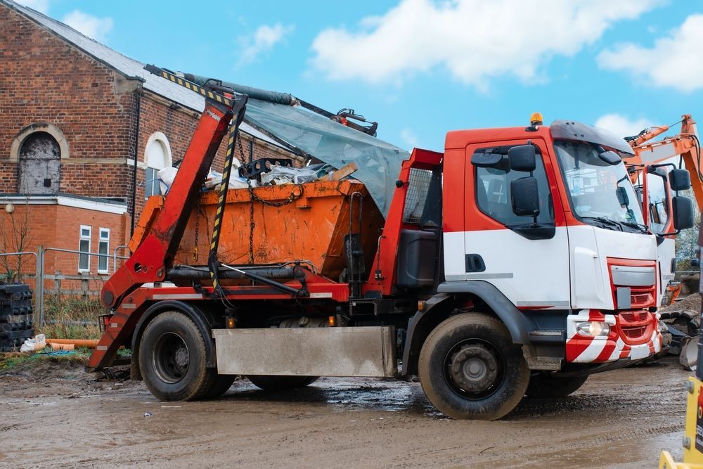 Orange-and-white Truck Parked Beside a Brick Building — Barkly Hire in Karumba, QLD
