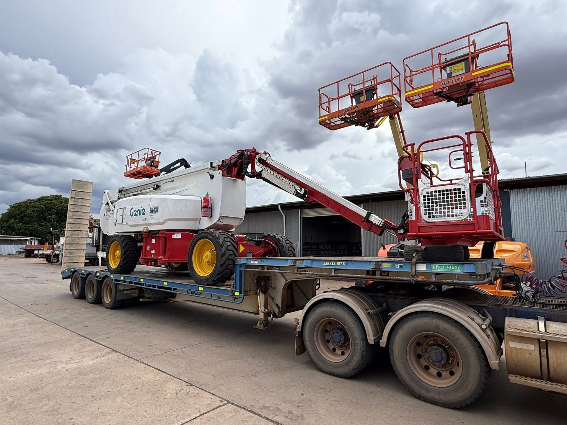 Red Boom Lift and White Tanker Truck Loaded on a Flatbed Trailer — Barkly Hire in Camooweal, QLD