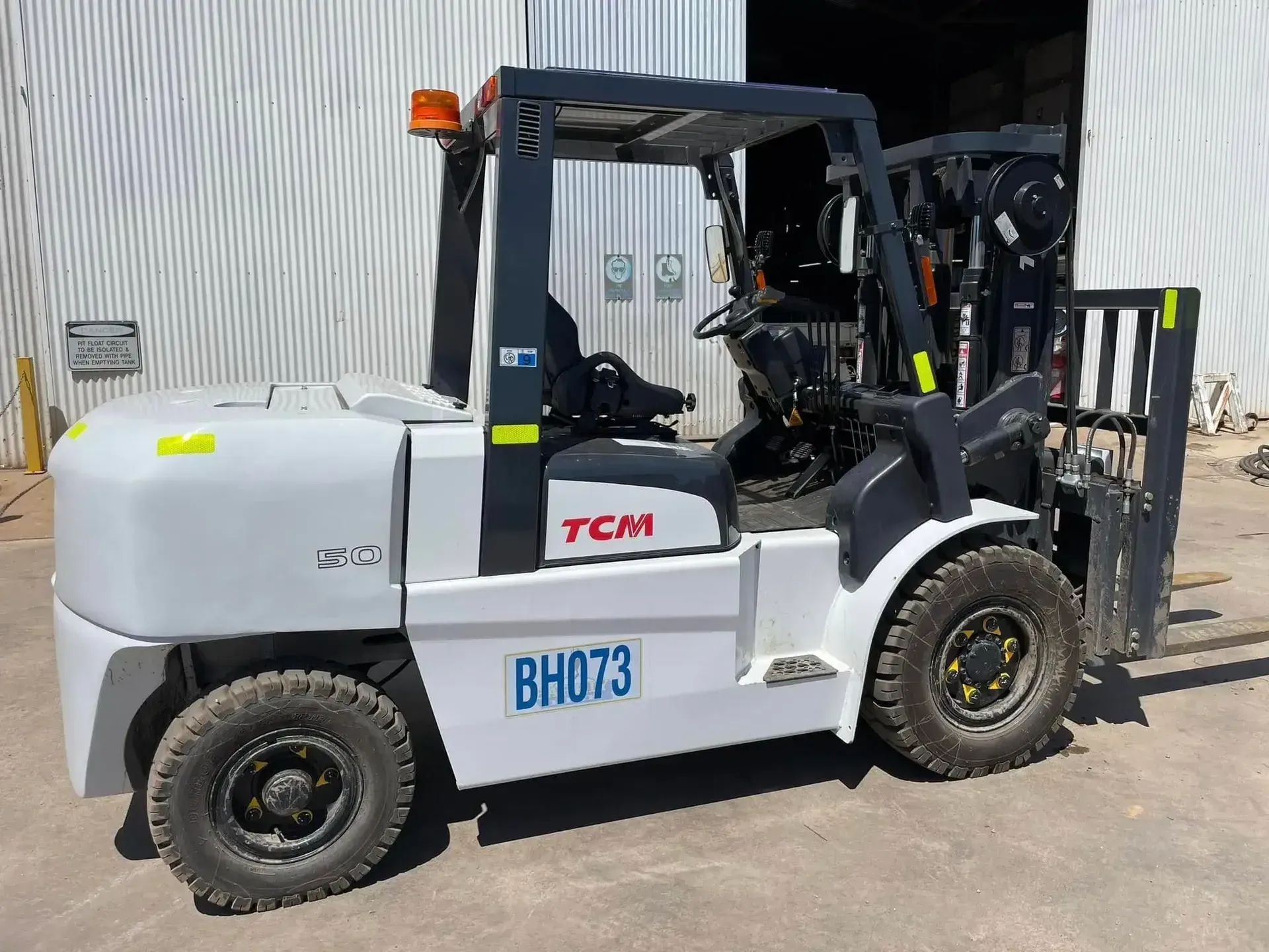 Grey Tcm Forklift Parked Outdoors Beside a Warehouse — Barkly Hire in Karumba, QLD