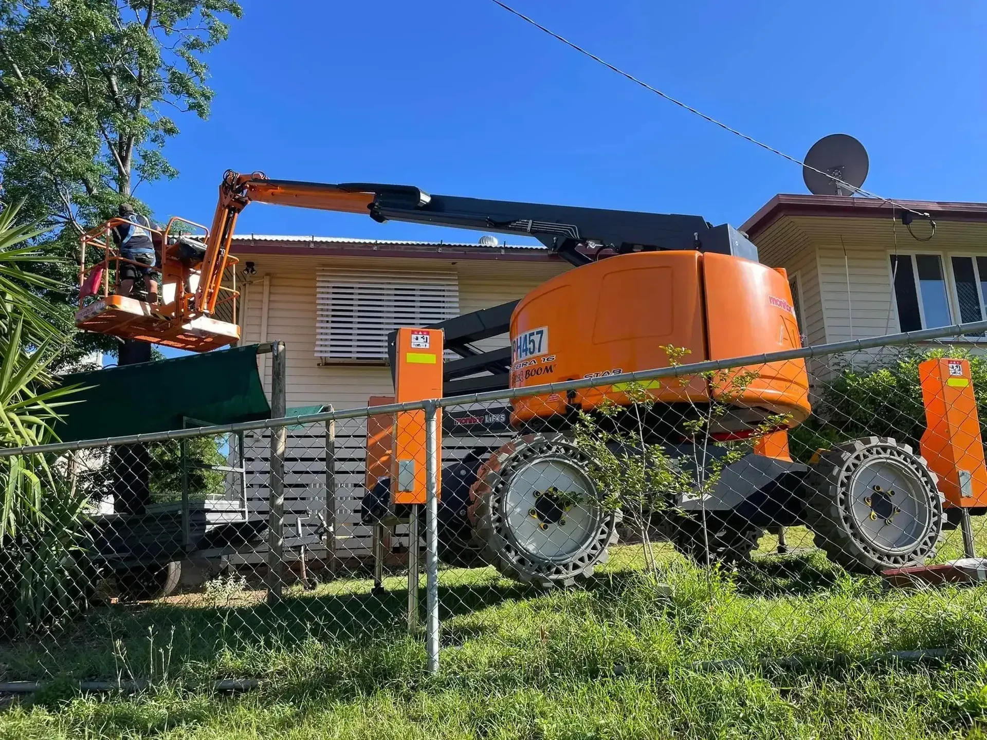 Orange Boom Lift Beside a House — Barkly Hire in Camooweal, QLD