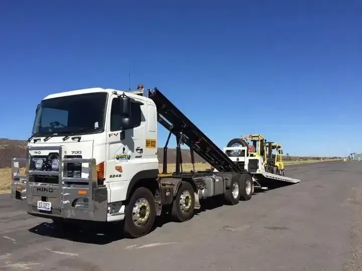 White Tow Truck Carrying a Black Car on a Flatbed Ramp — Barkly Hire in Dugald River, QLD