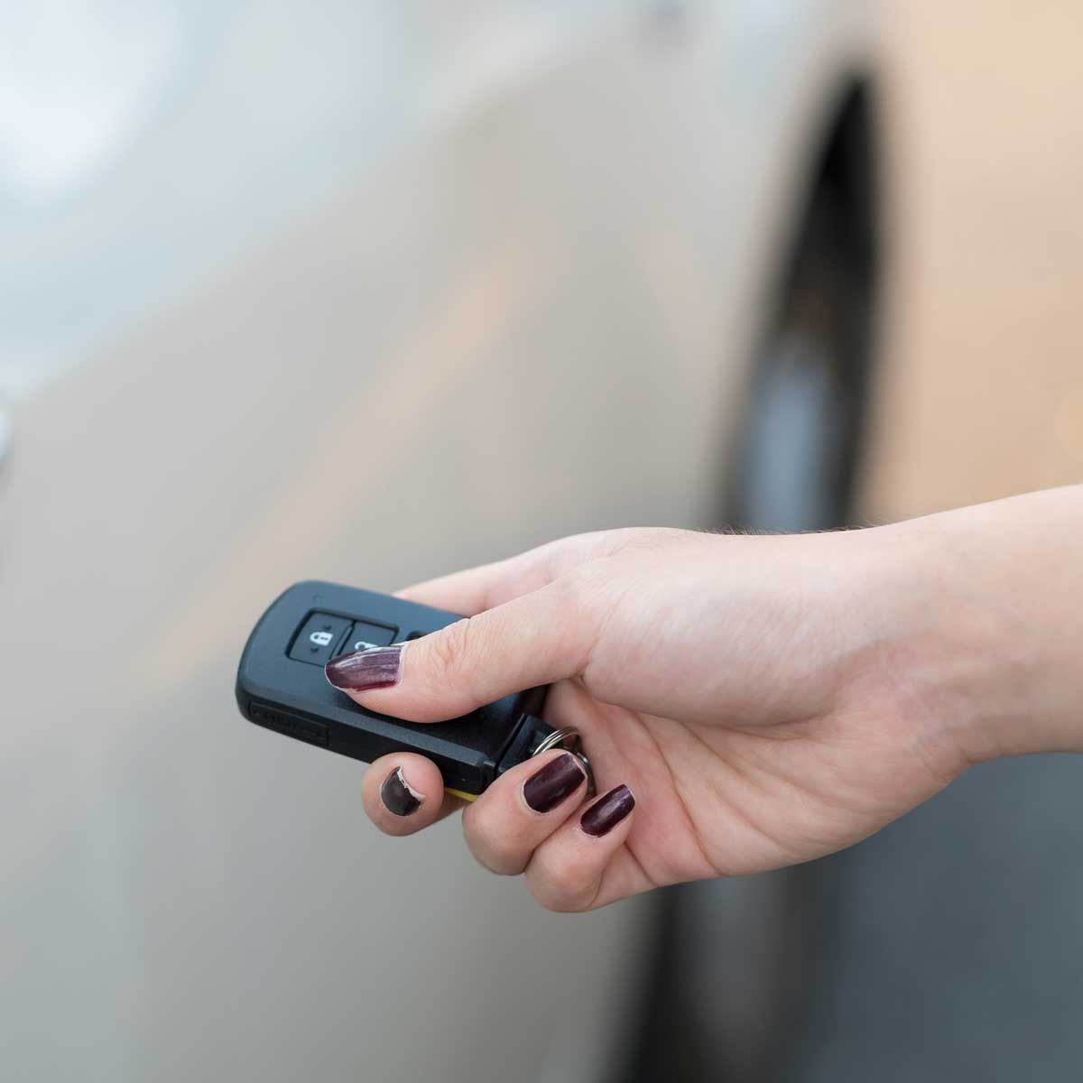 A woman is holding a car key in her hand