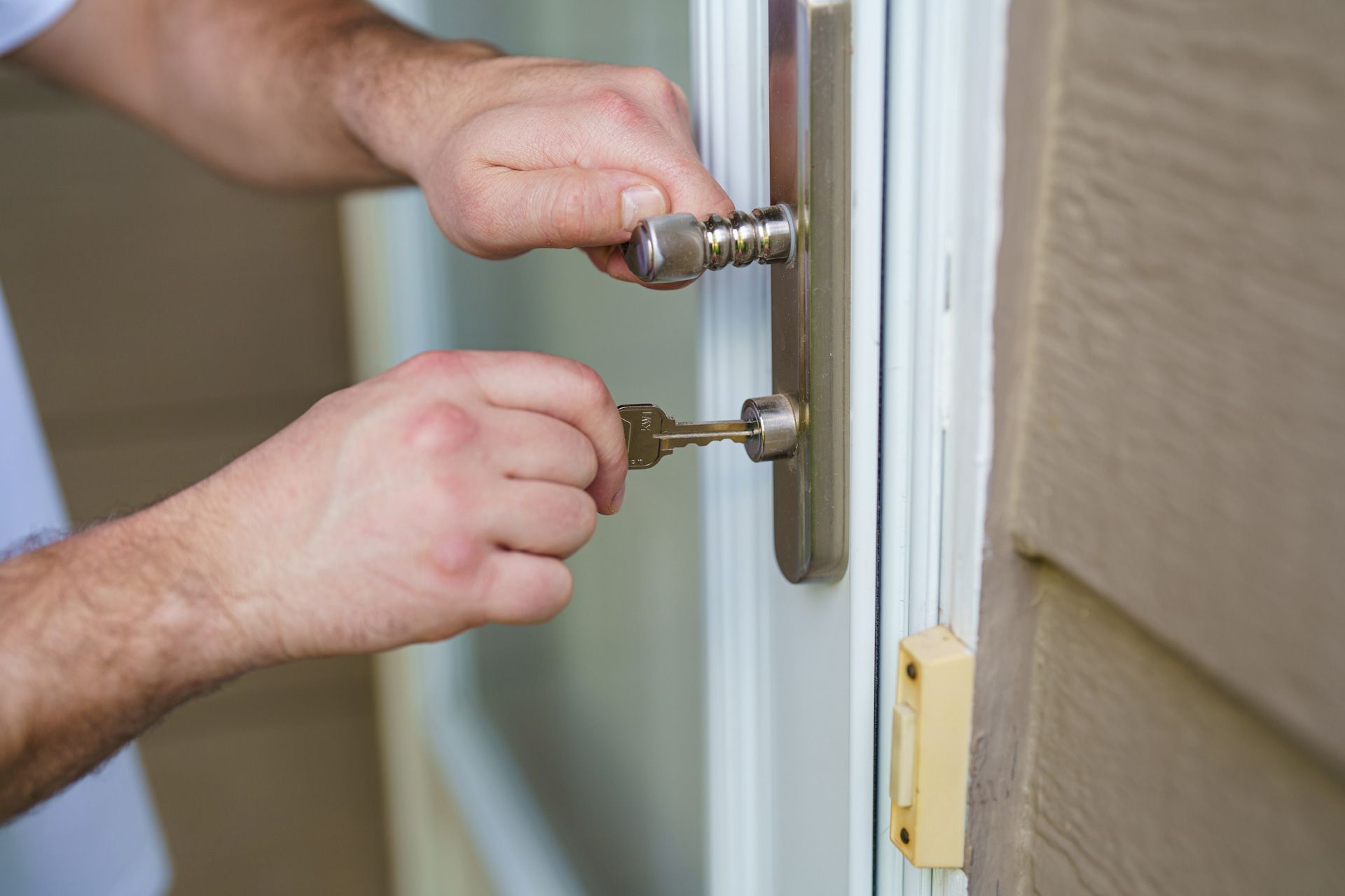 A man is opening a door with a key.