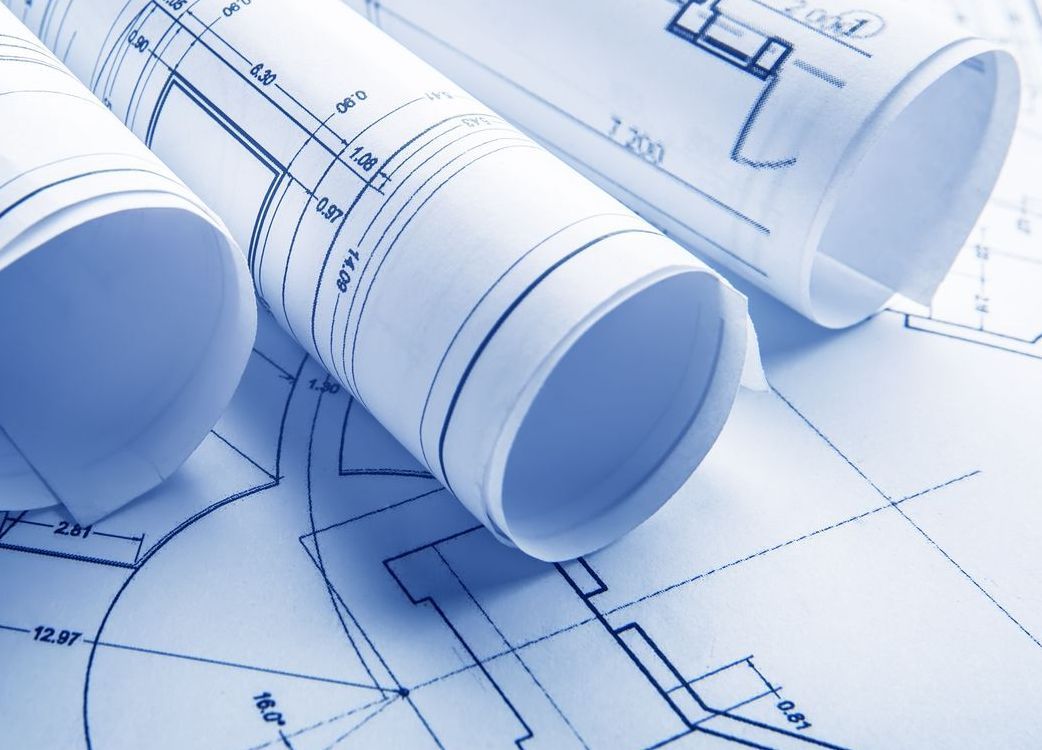 Deux rouleaux de plans sont posés sur une table