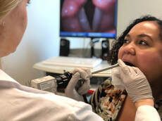 Dr. Elizabeth Self Burckardt checking the throat of a patient