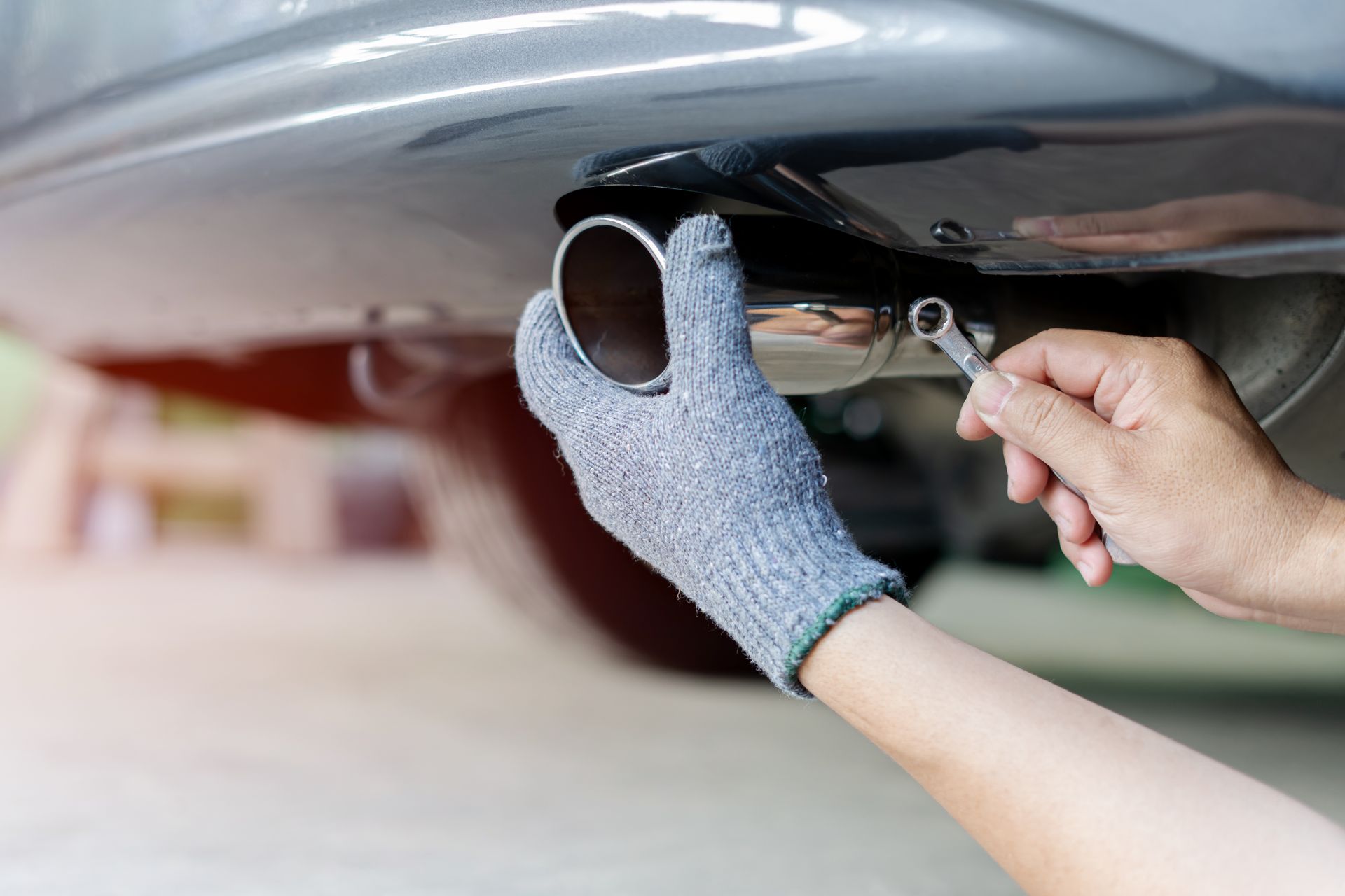 A man is working on car muffler
