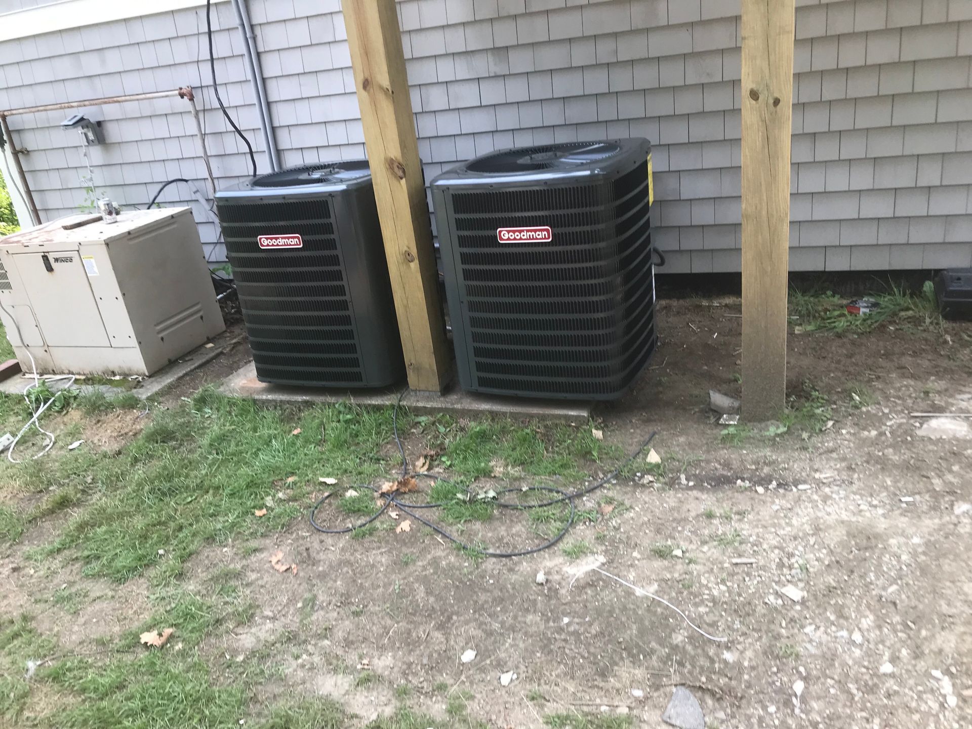 Person in cap and gloves servicing an air conditioner on a wall.
