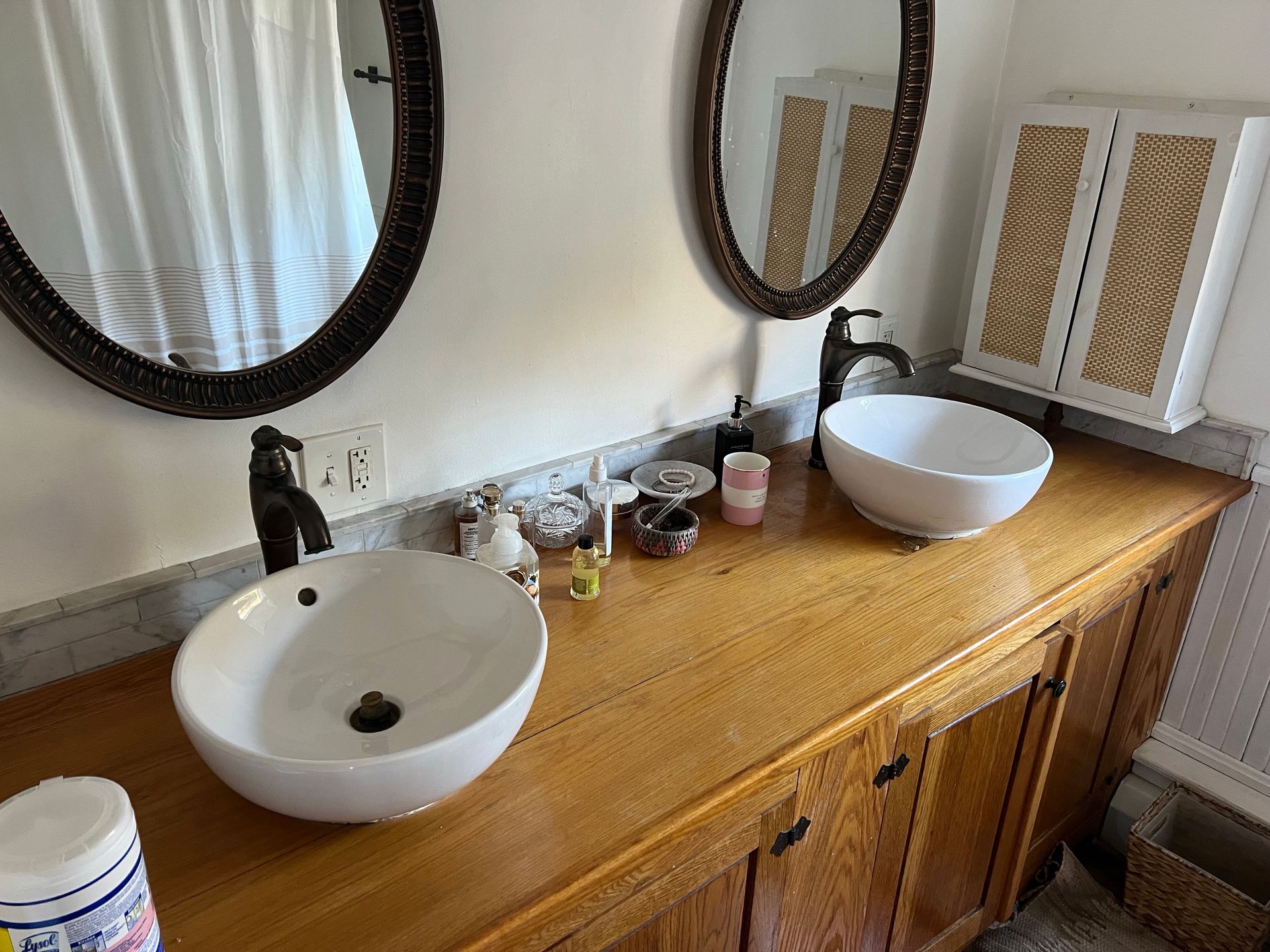 Plumber using a wrench to repair a sink drain, wearing gloves.