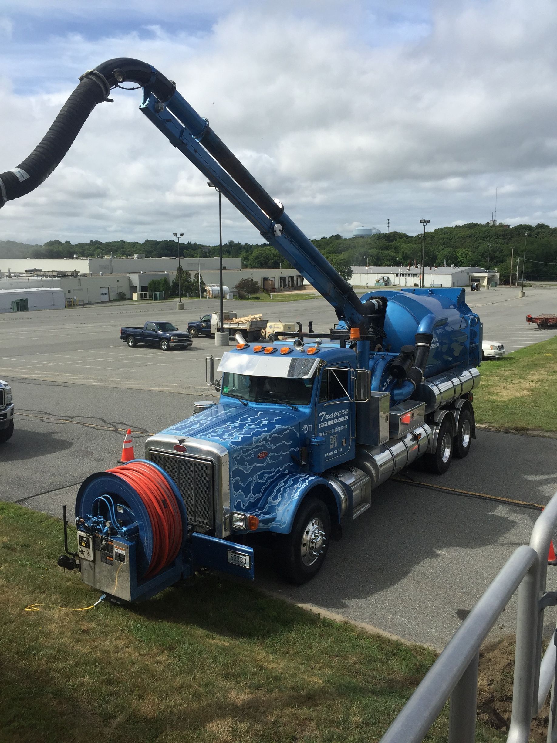 Asphalt being jackhammered, exposing concrete and causing debris. White and blue paint markings visible.