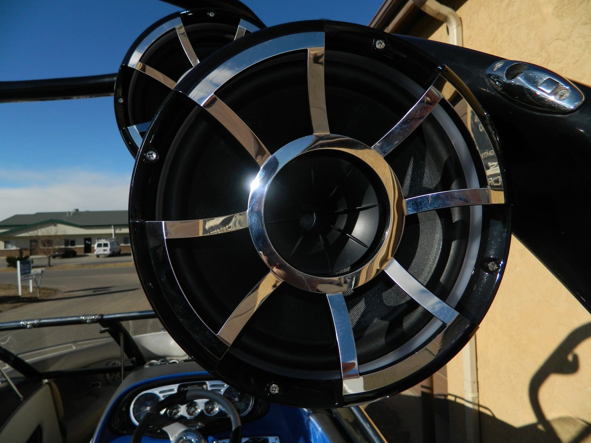 Close-up of a black aircraft engine intake with shiny metal blades on a yellow plane, outdoors under blue sky