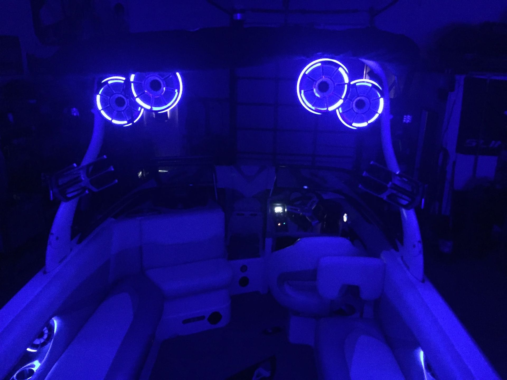 Blue-lit car interior with glowing speakers and neon accent lights at night