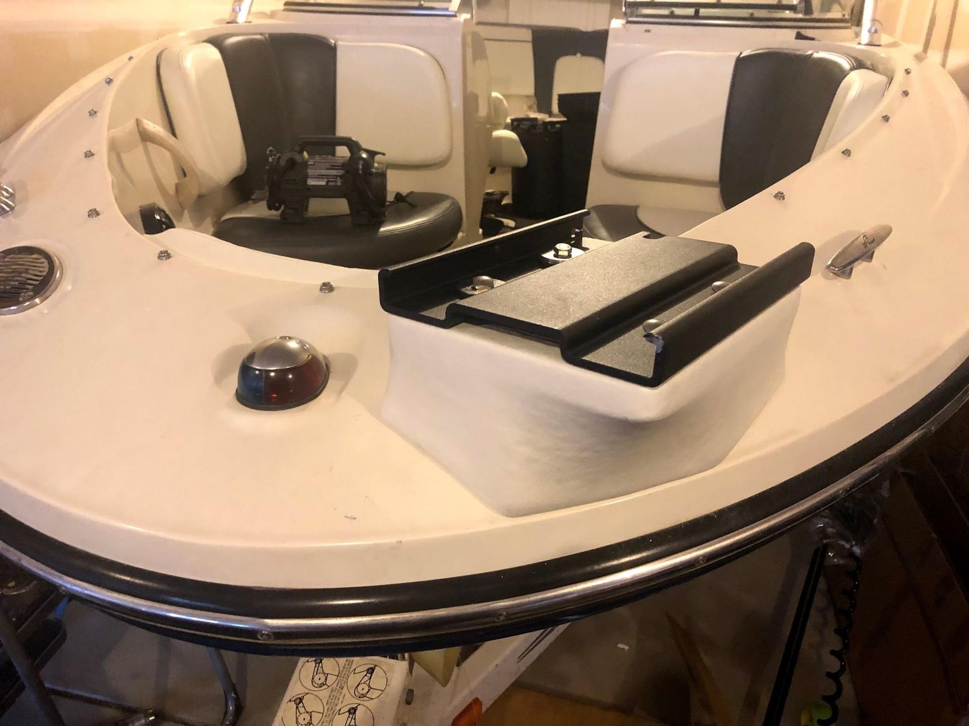 White boat cockpit with black seating and a center console on the water