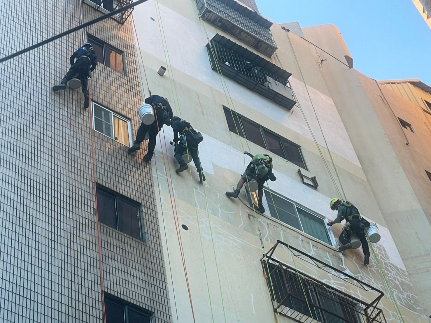 A group of people are climbing up the side of a building.