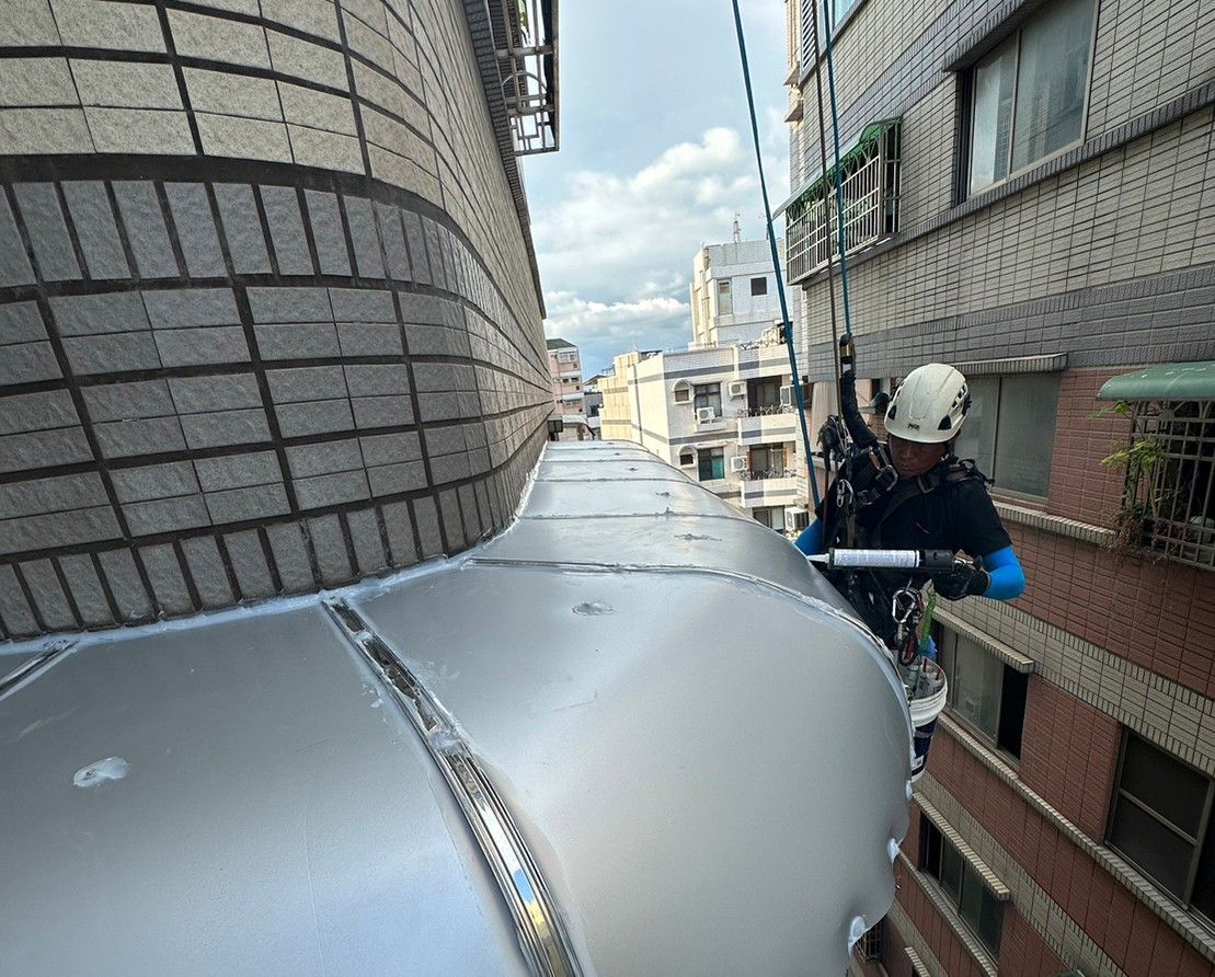 A man is working on the side of a building.