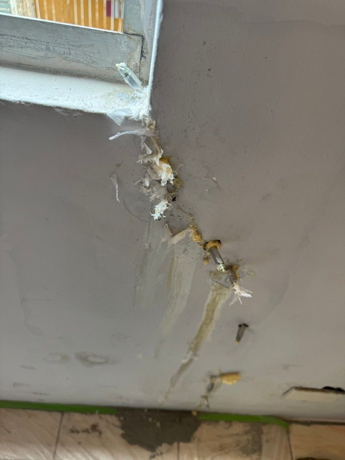 A ceiling with a hole in it and a window.