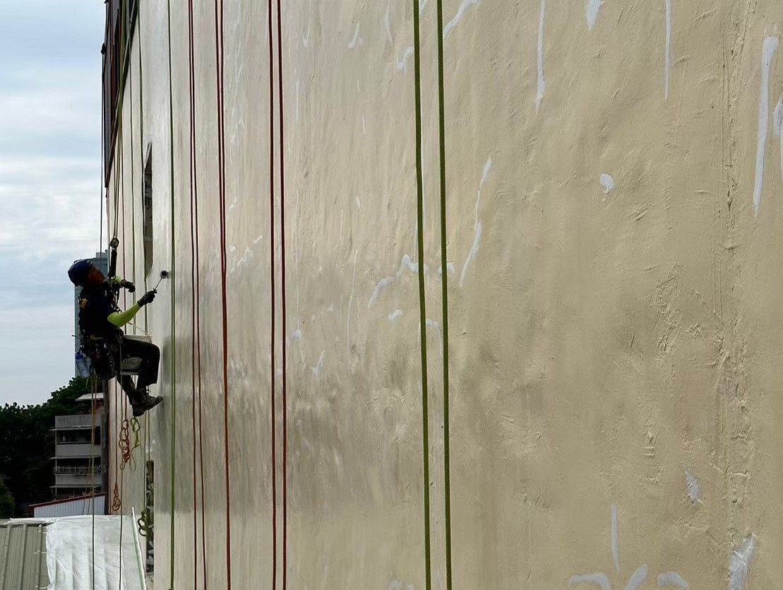 A man is climbing up the side of a building.