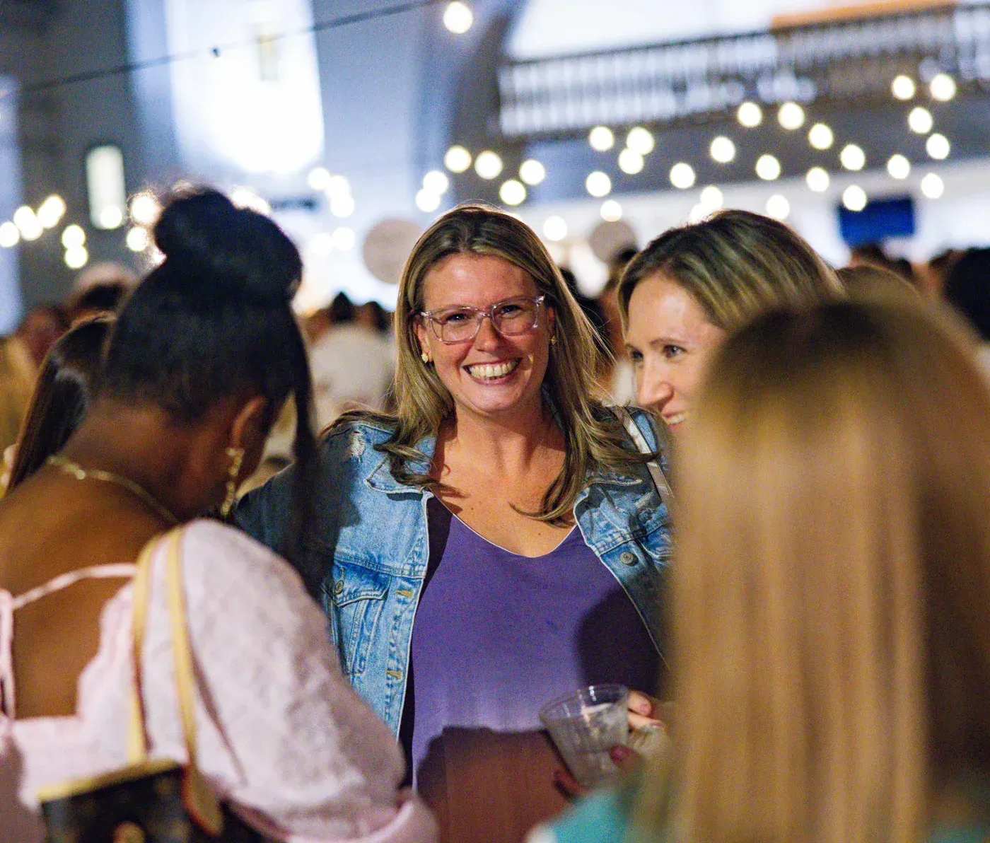 Friends together under string lights on the plaza