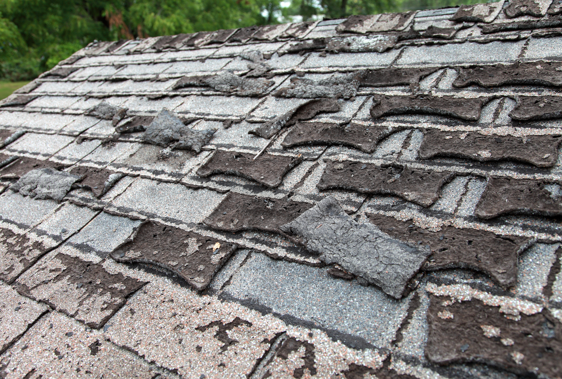 A close up of a roof with a lot of shingles missing.