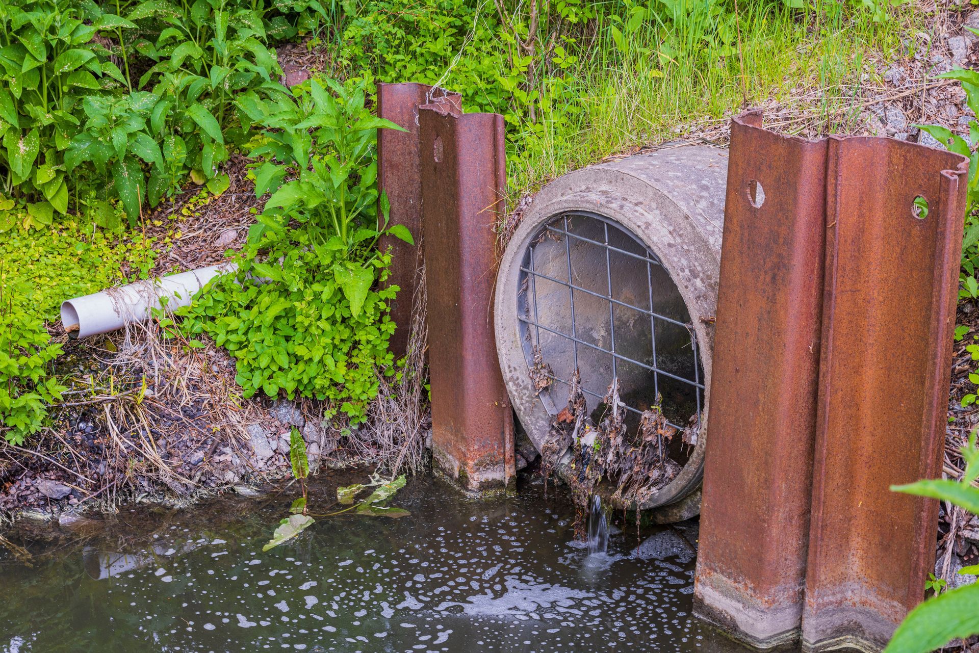 A Concrete Pipe Is Draining Into A Body Of Water — Byram, MS — Dier’s Vacuum Service