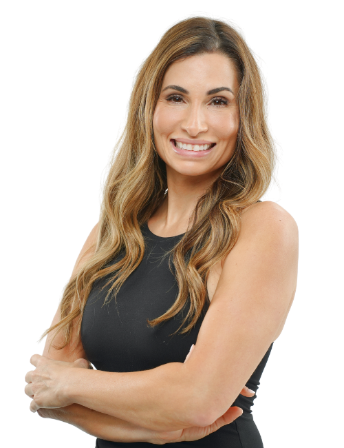 A woman in a black tank top is smiling with her arms crossed.