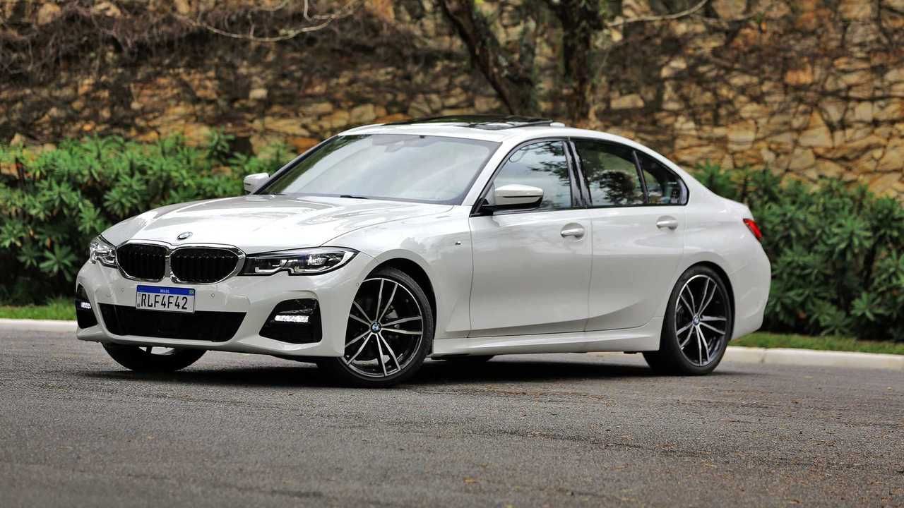 White BMW sedan parked on a road beside greenery