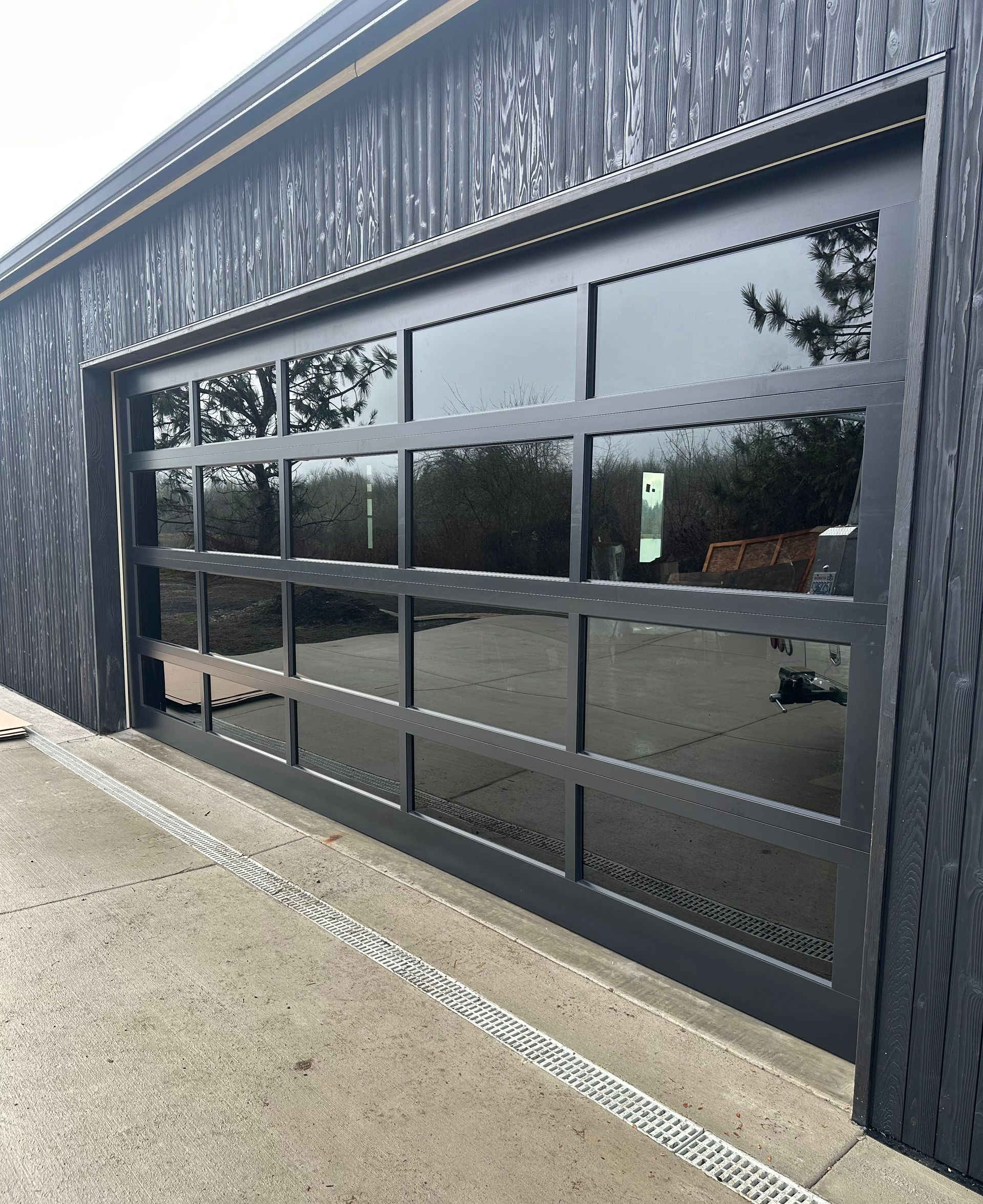 Modern glass garage door installation in Lacey, WA on contemporary home
