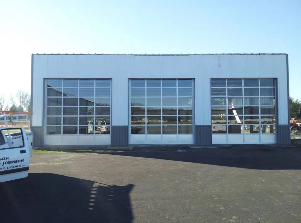 Commercial garage doors with full glass panels on service building