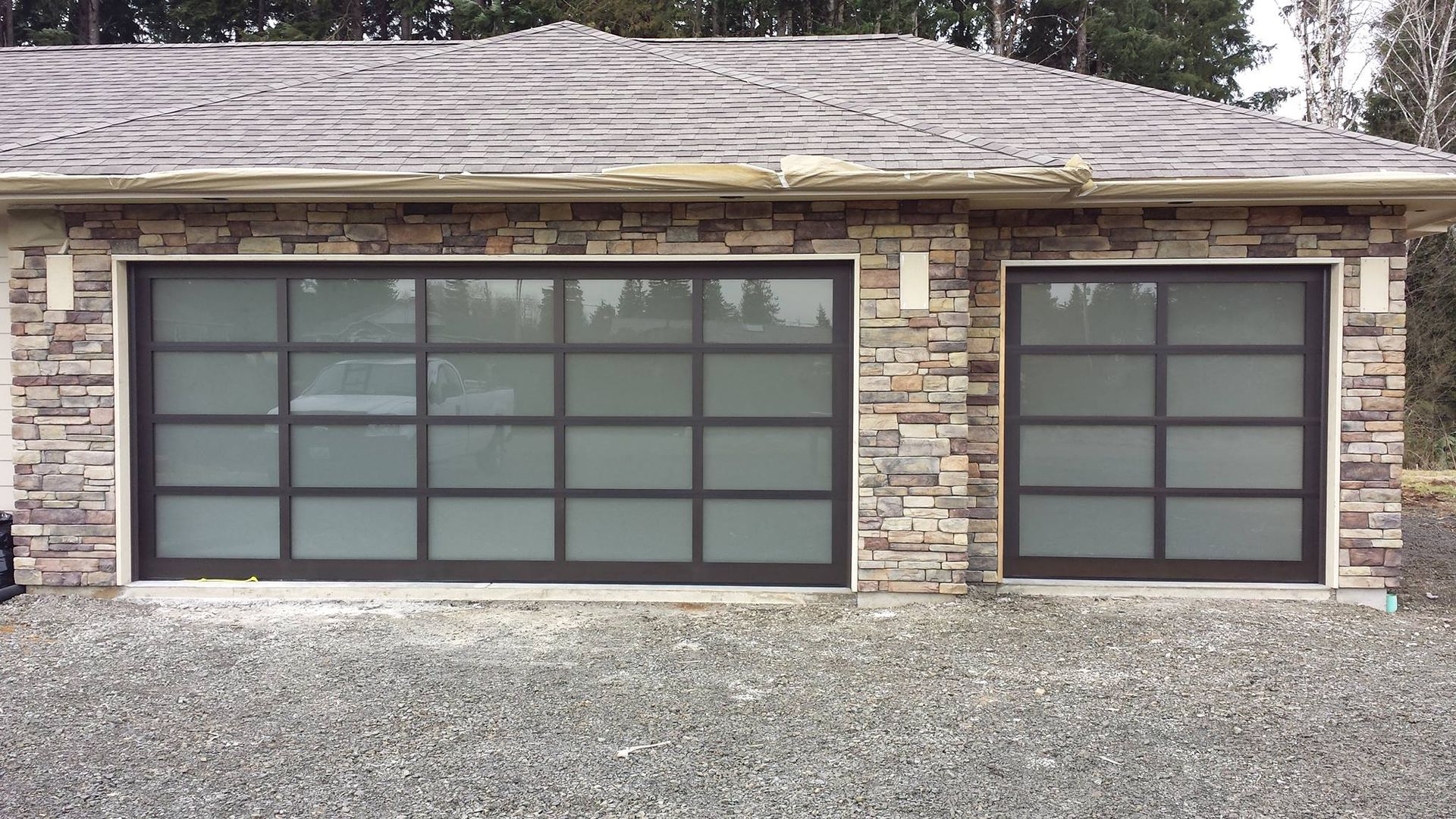 Wood carriage-style garage door with windows and decorative hardware