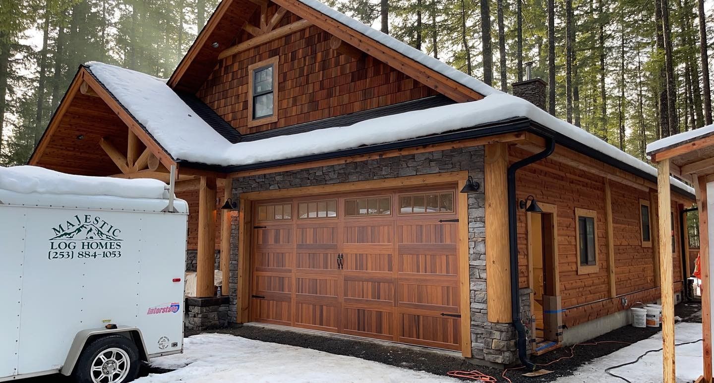 Wood garage door on cabin-style home in snowy setting