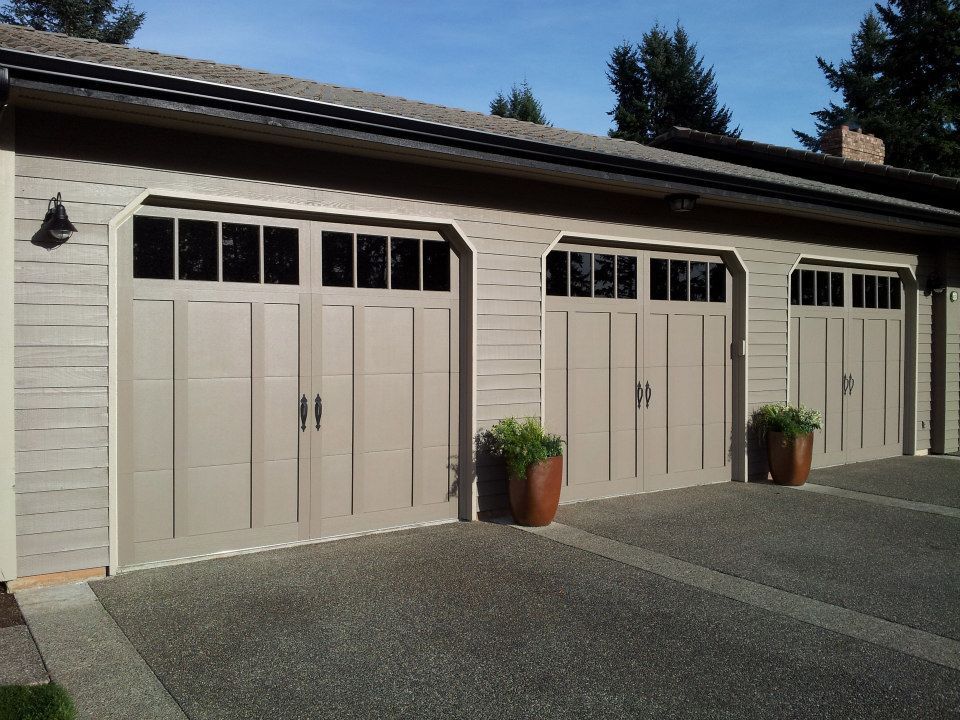 Carriage-style garage doors on residential home with exterior lighting