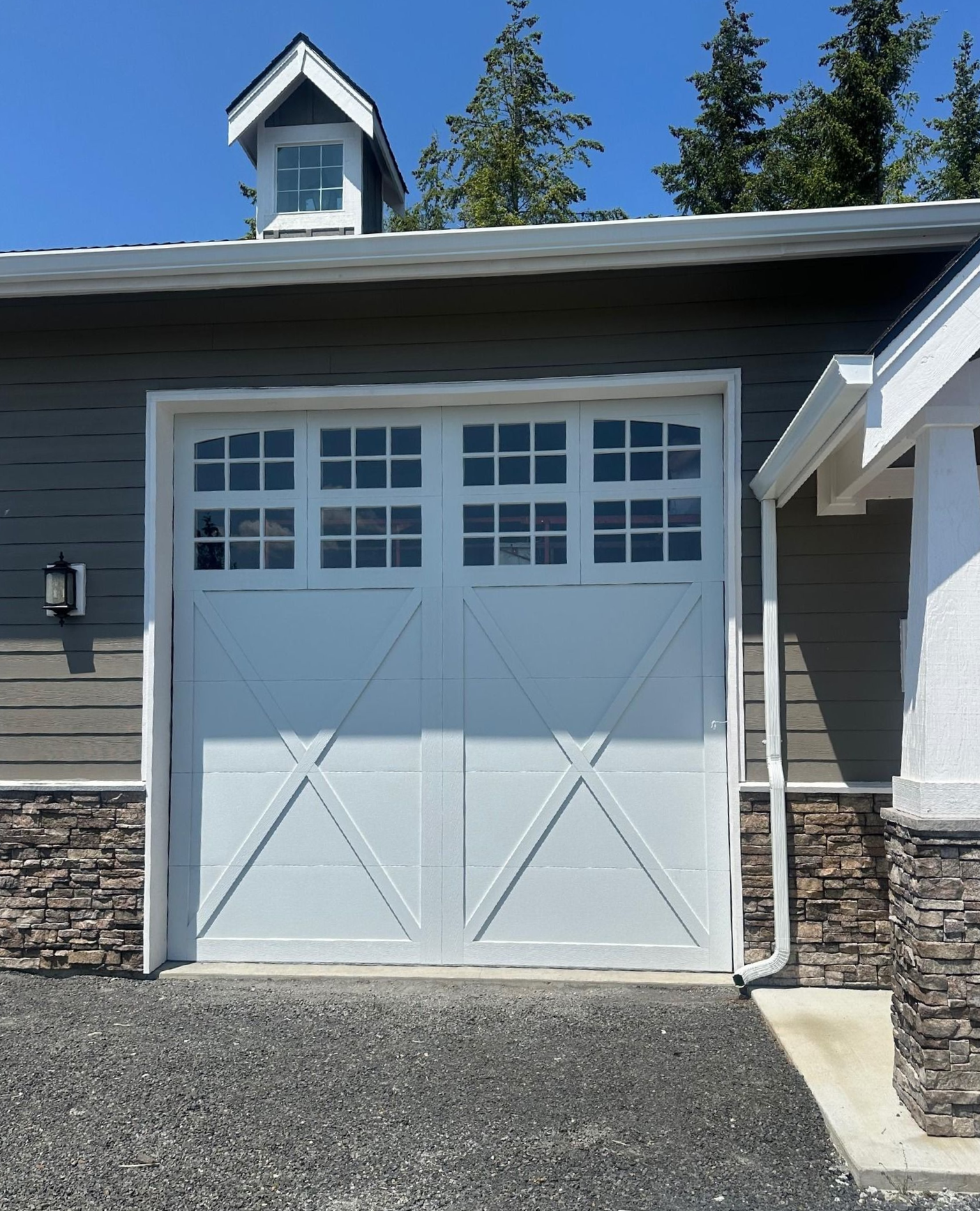 White carriage style residential garage door with windows on a modern home exterior in Olympia, WA