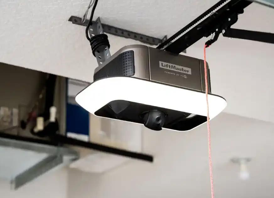 A LiftMaster garage door opener with a built-in camera, mounted to a garage ceiling.