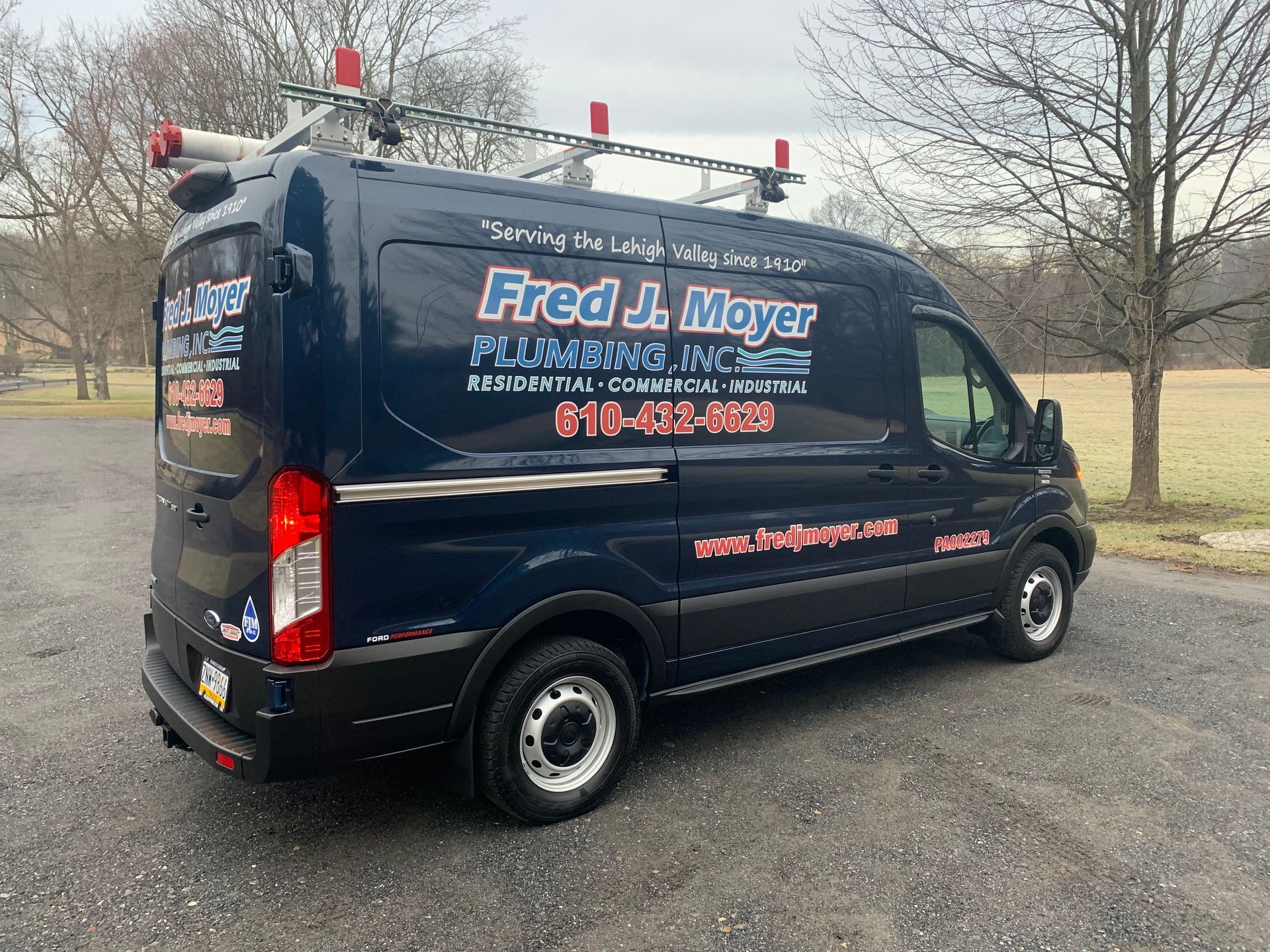 Black Fred A. Meyer plumbing service van parked on a gravel lot with trees in the background - Allentown, PA — Fred J Moyer Plumbing Inc Black Fred A. Meyer plumbing service van parked on a gravel lot with trees in the background