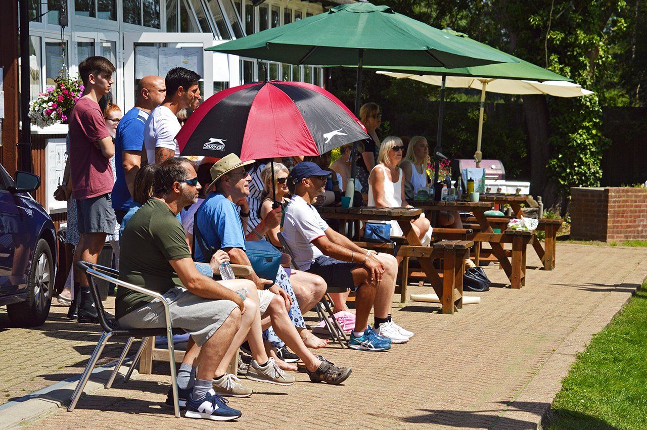 An image of club members watching tennis at Pinner Lawn Tennis Club