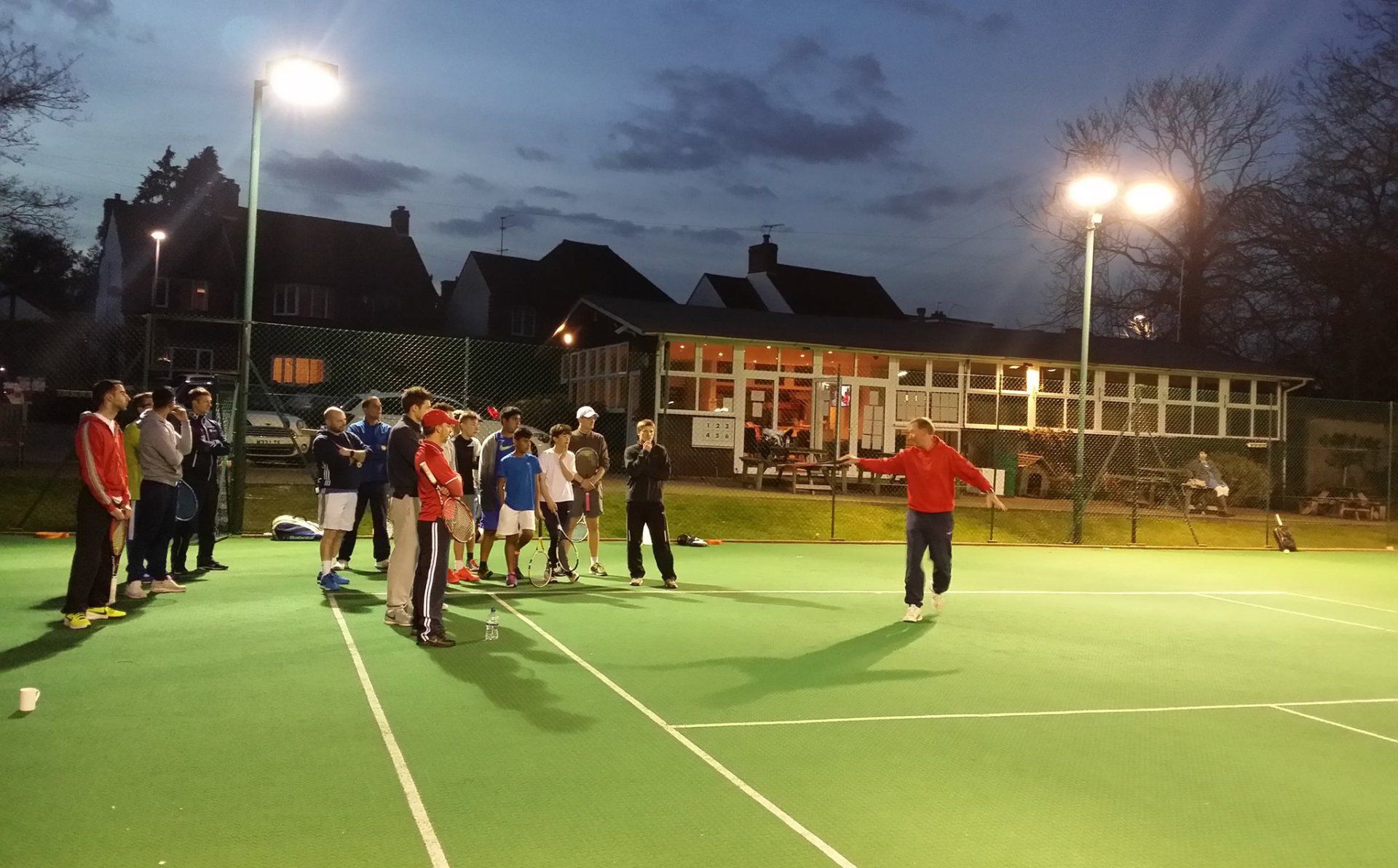 An image of a group of tennis players at a coaching session at Pinner Lawn Tennis Club