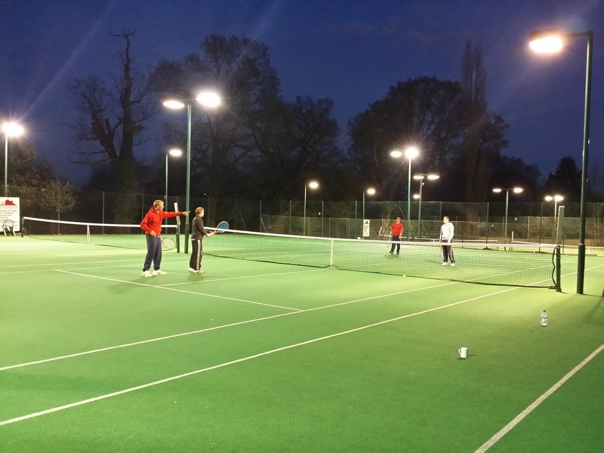 An image of three junior tennis players and a coach at Pinner Lawn Tennis Club