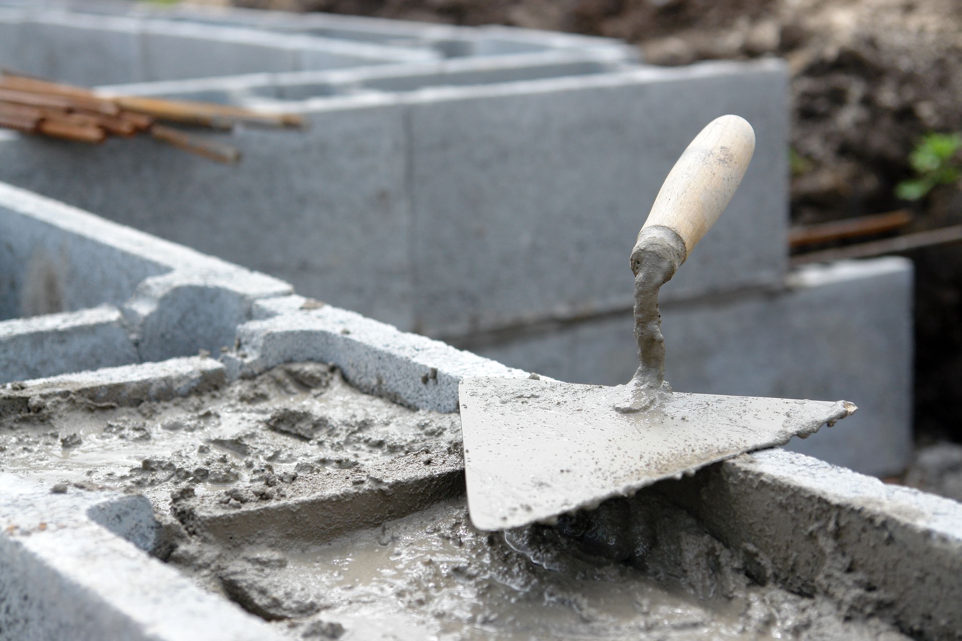 A trowel is sitting on top of a pile of concrete.