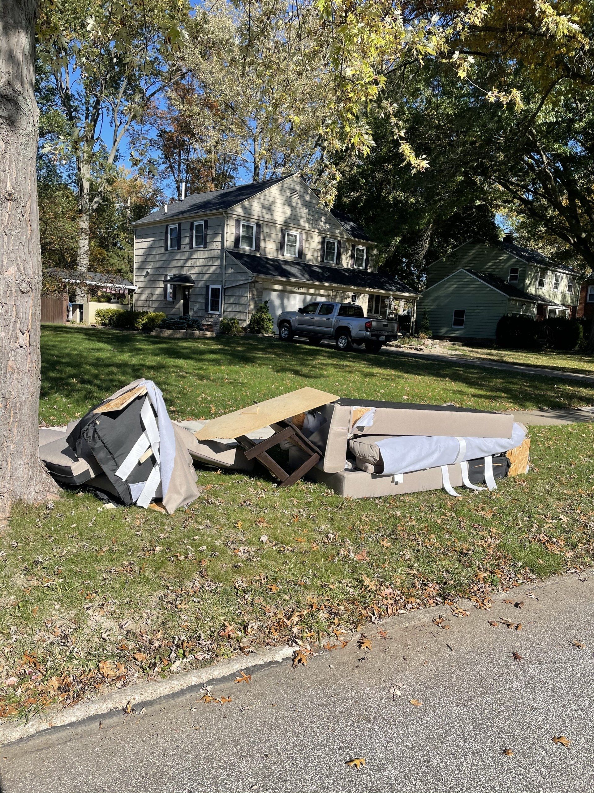 Junk Pickup Before Picture. Pile of couches and trash on treelawn