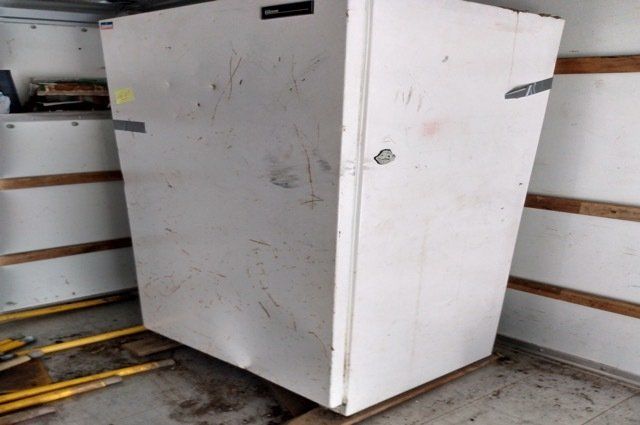 a refrigerator with duct tape on it inside of truck