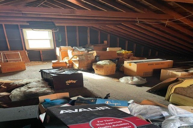 miscellaneous junk inside an attic with a window