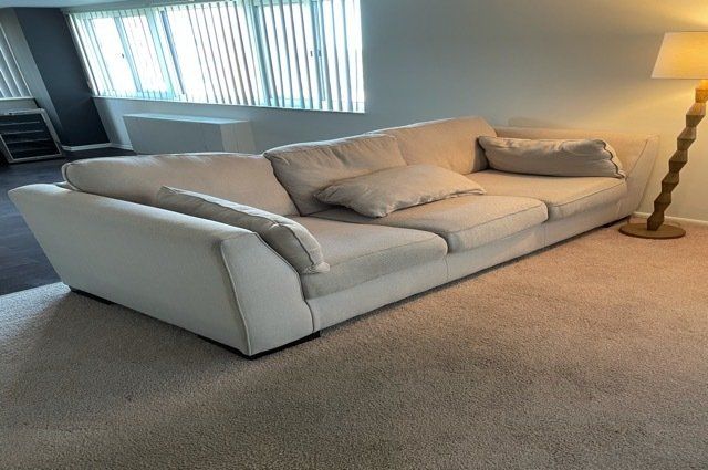 a white leather couch and a lamp