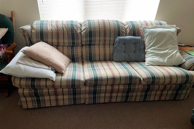 Striped Couch and pillows in front of a window