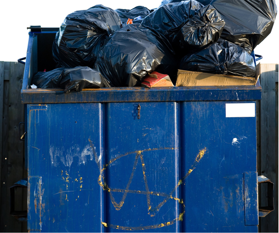 blue dumpster that is overflowing with trash